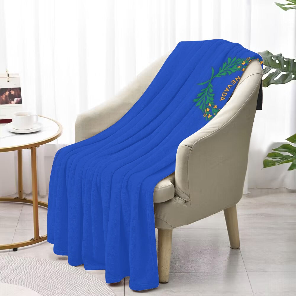 Blue Luv My Flag blanket draped on beige armchair.