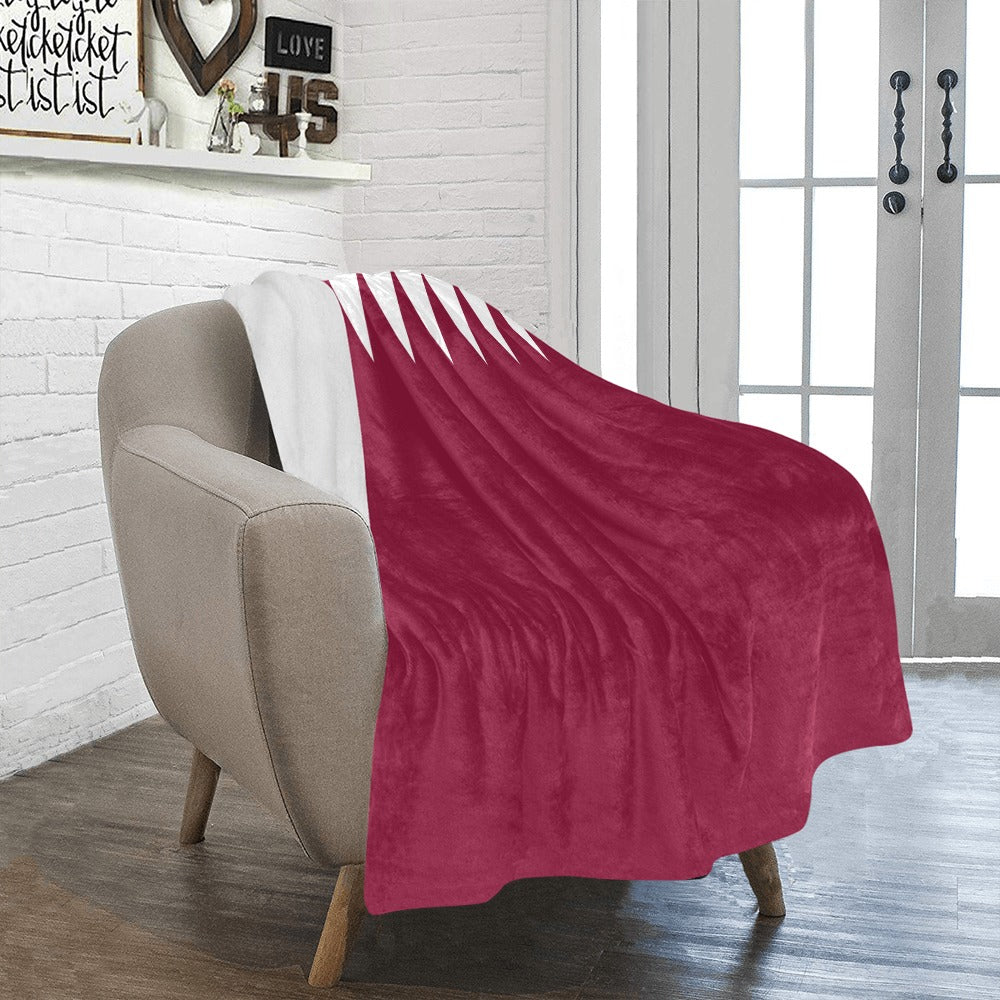 Cozy chair with Luv My Flag Qatar-themed blanket draped.