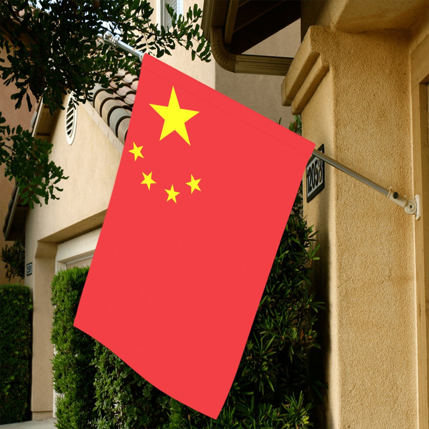 Red flag with yellow stars displayed outside, by Luv My Flag.
