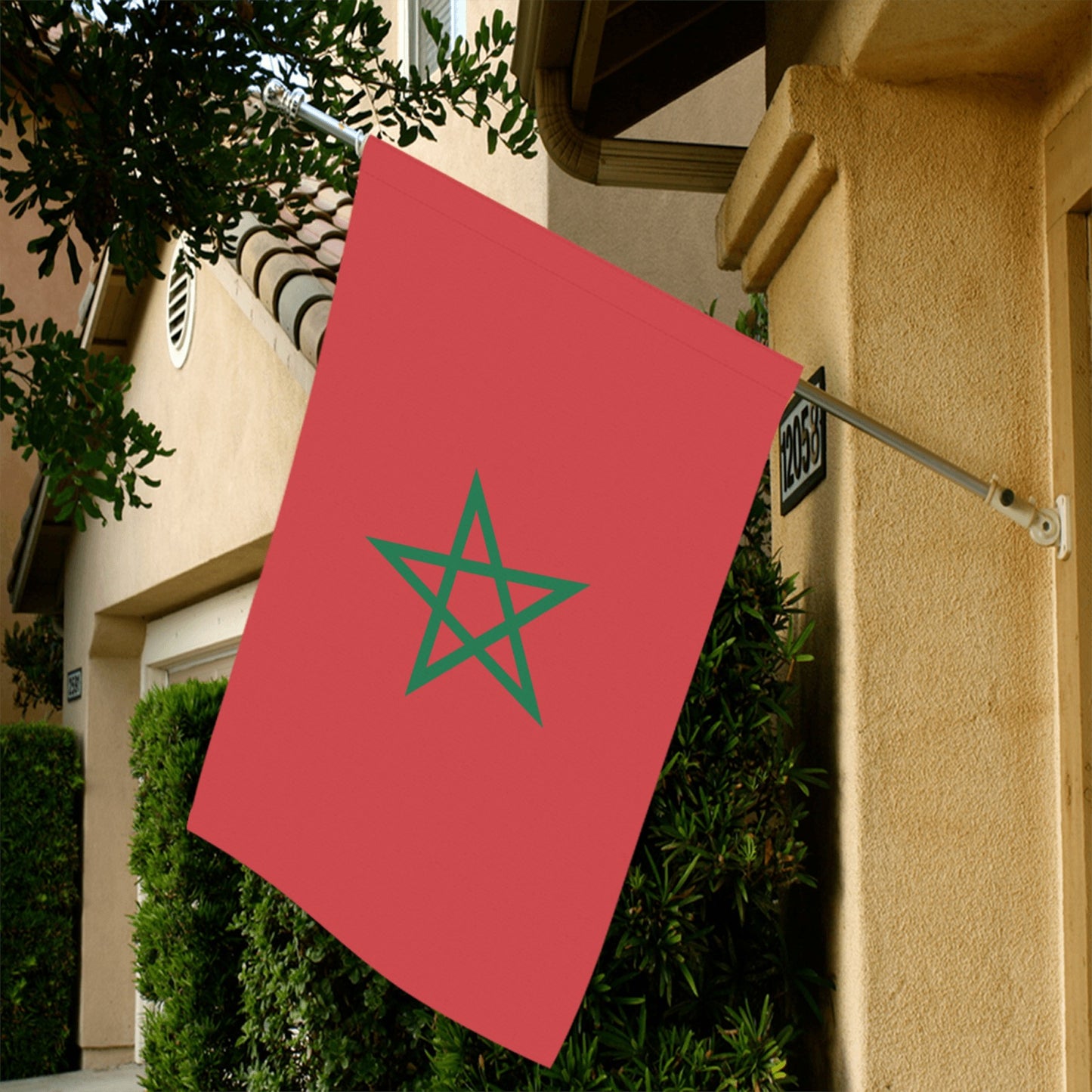 Luv My Flag Moroccan flag displayed outside beige house.