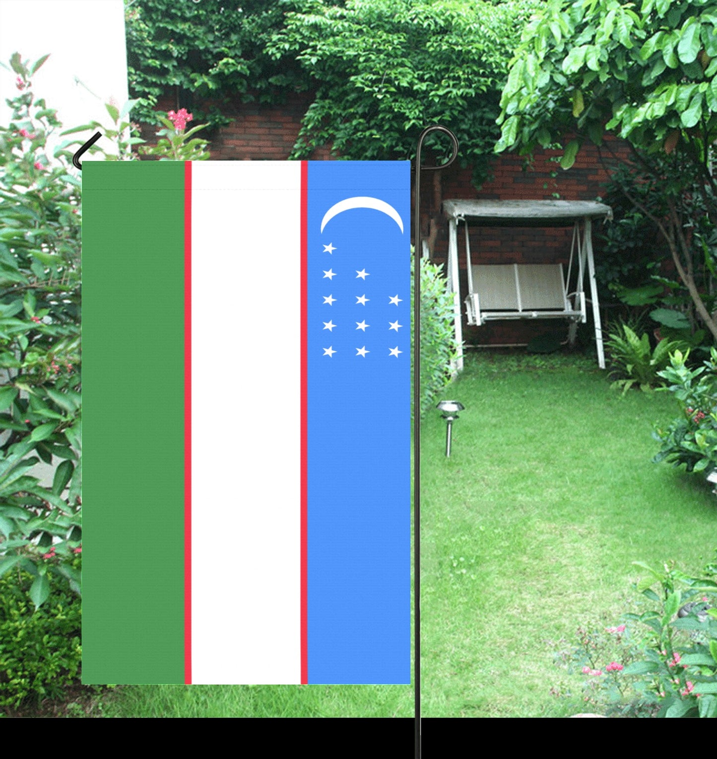 Luv My Flag Uzbekistan garden flag with lush greenery backdrop.