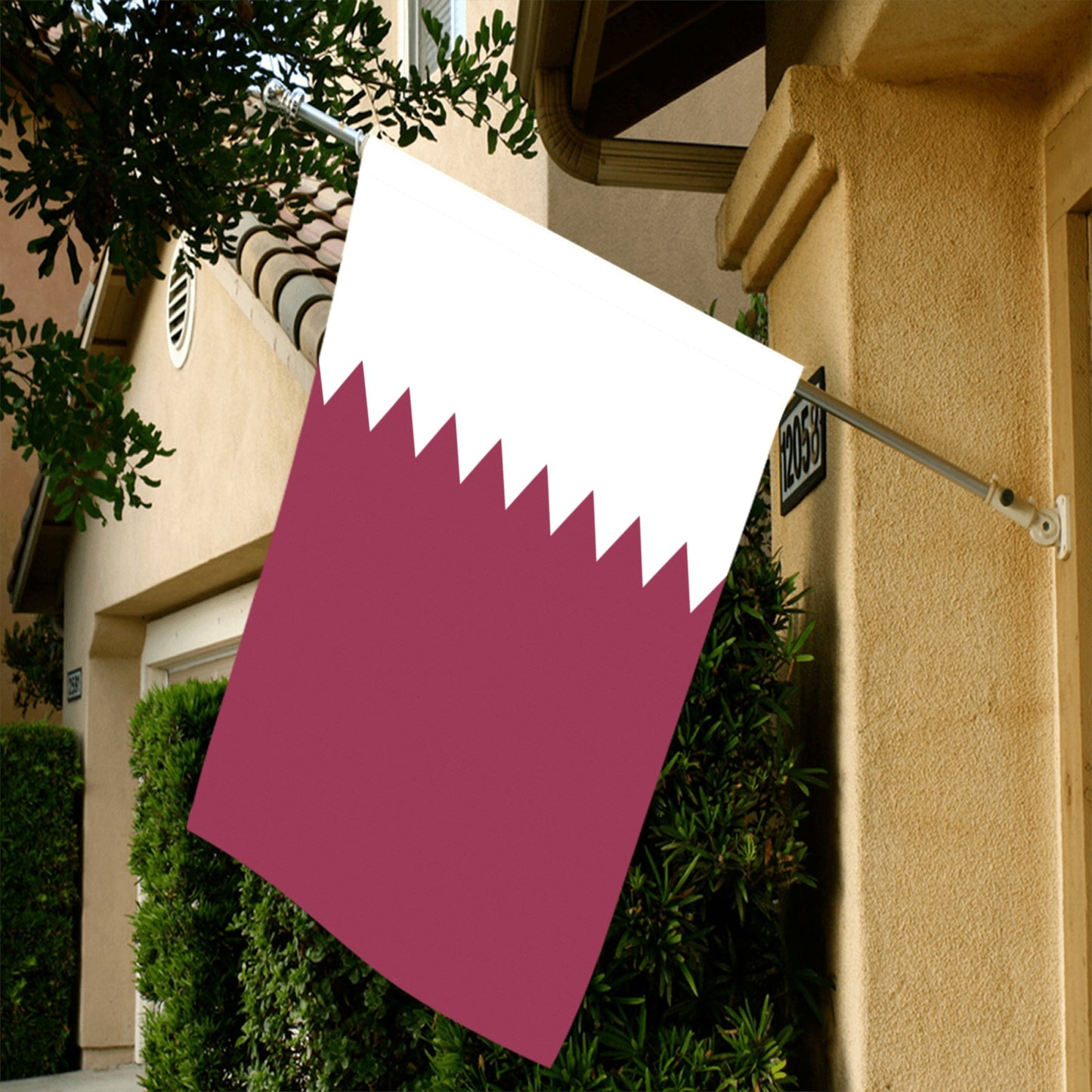 Luv My Flag Qatar flag displayed on house exterior.