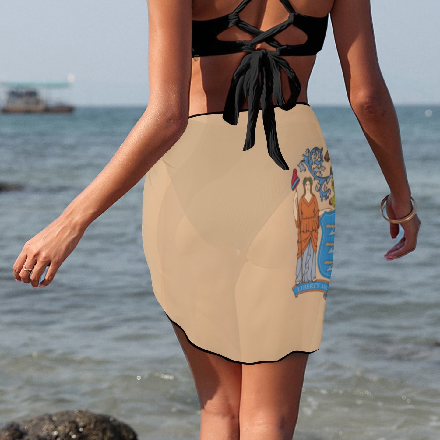 Woman wearing Luv My Flag swimsuit cover-up at beach.