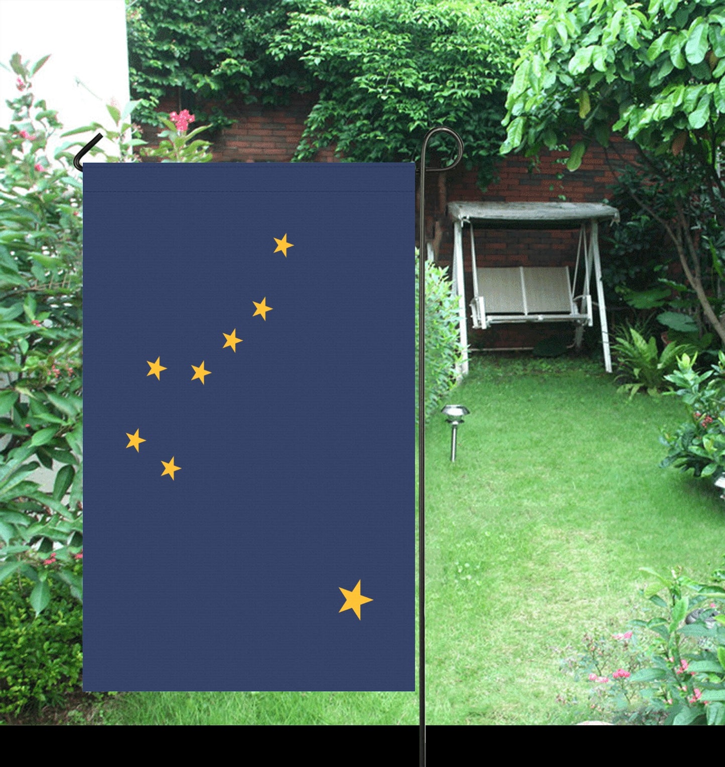 Blue "Luv My Flag" with yellow stars in garden.