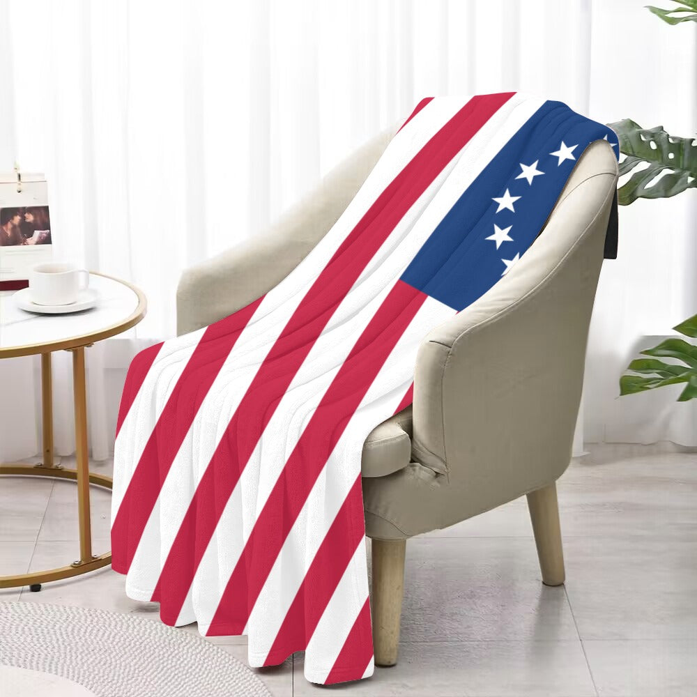 "Luv My Flag patriotic blanket draped over beige chair."