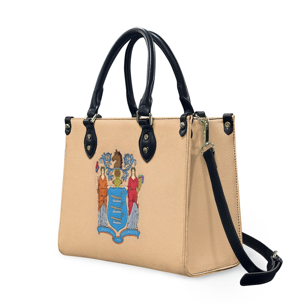 Tan handbag with black handles, crest design, Luv My Flag.