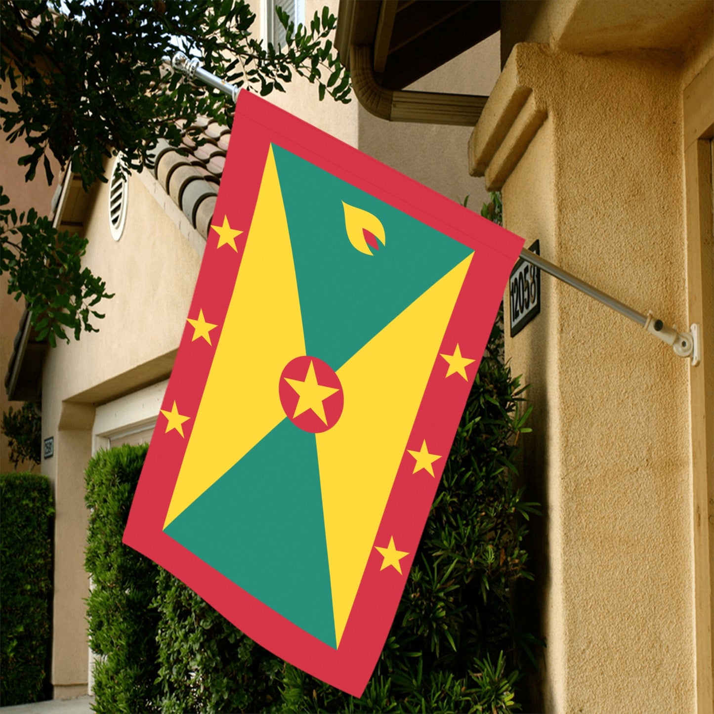 Luv My Flag Grenada flag displayed outside beige house.