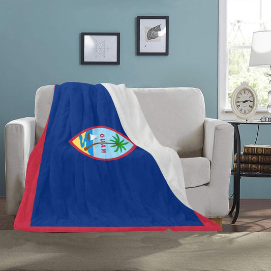 Luv My Flag Guam blanket draped over white couch.