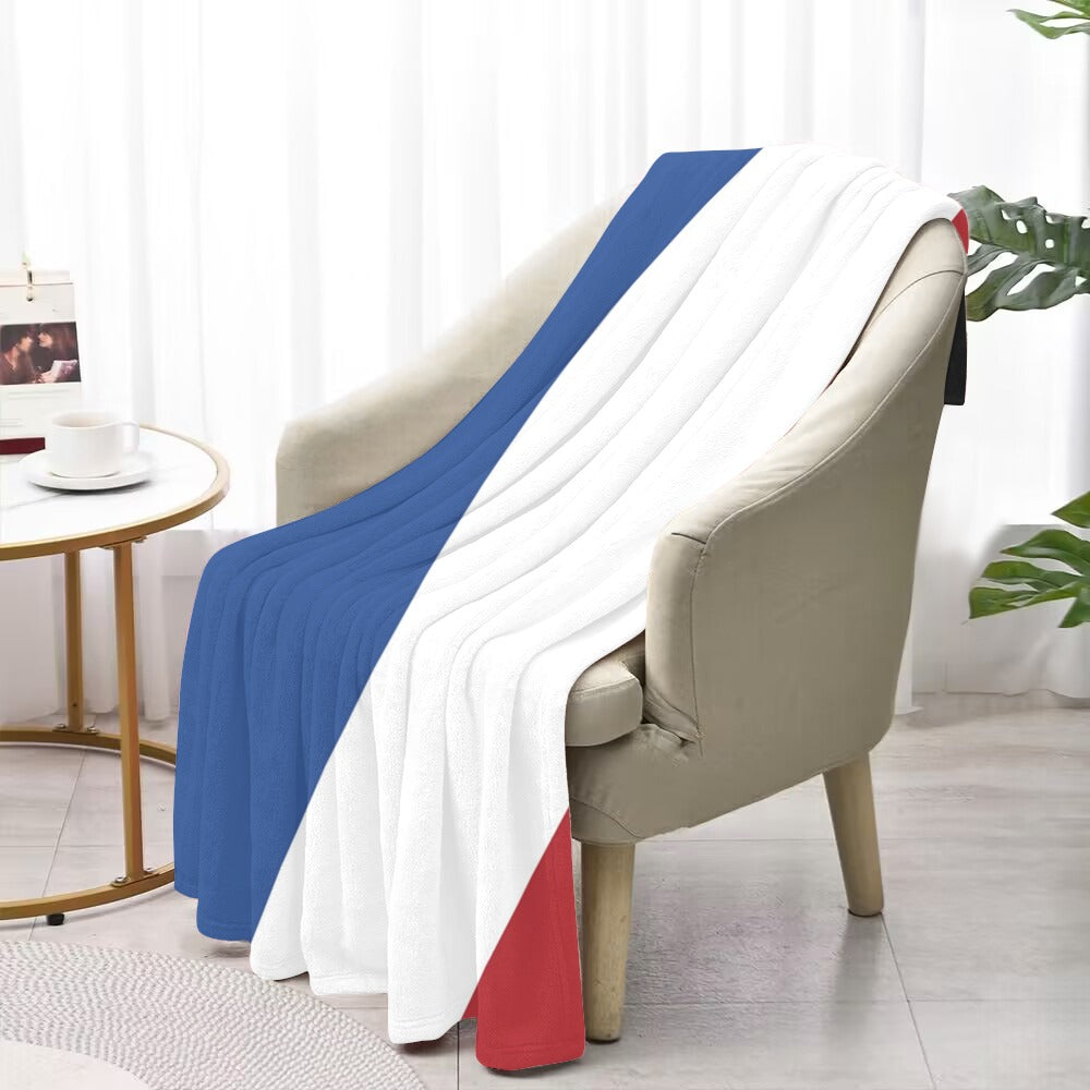 Luv My Flag tricolor blanket draped over beige armchair.