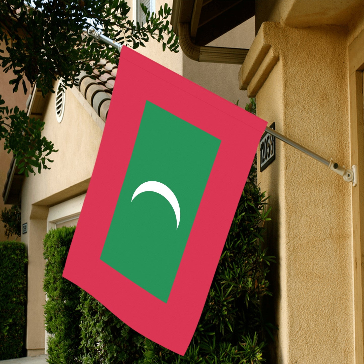 Luv My Flag Maldives flag displayed outside beige building.
