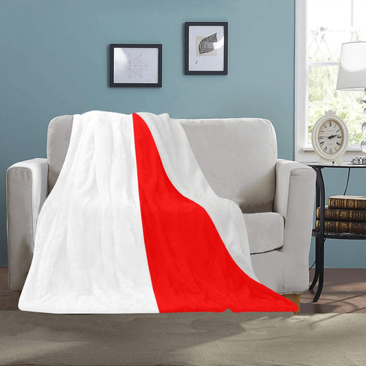 Cozy blanket with red and white design on sofa.