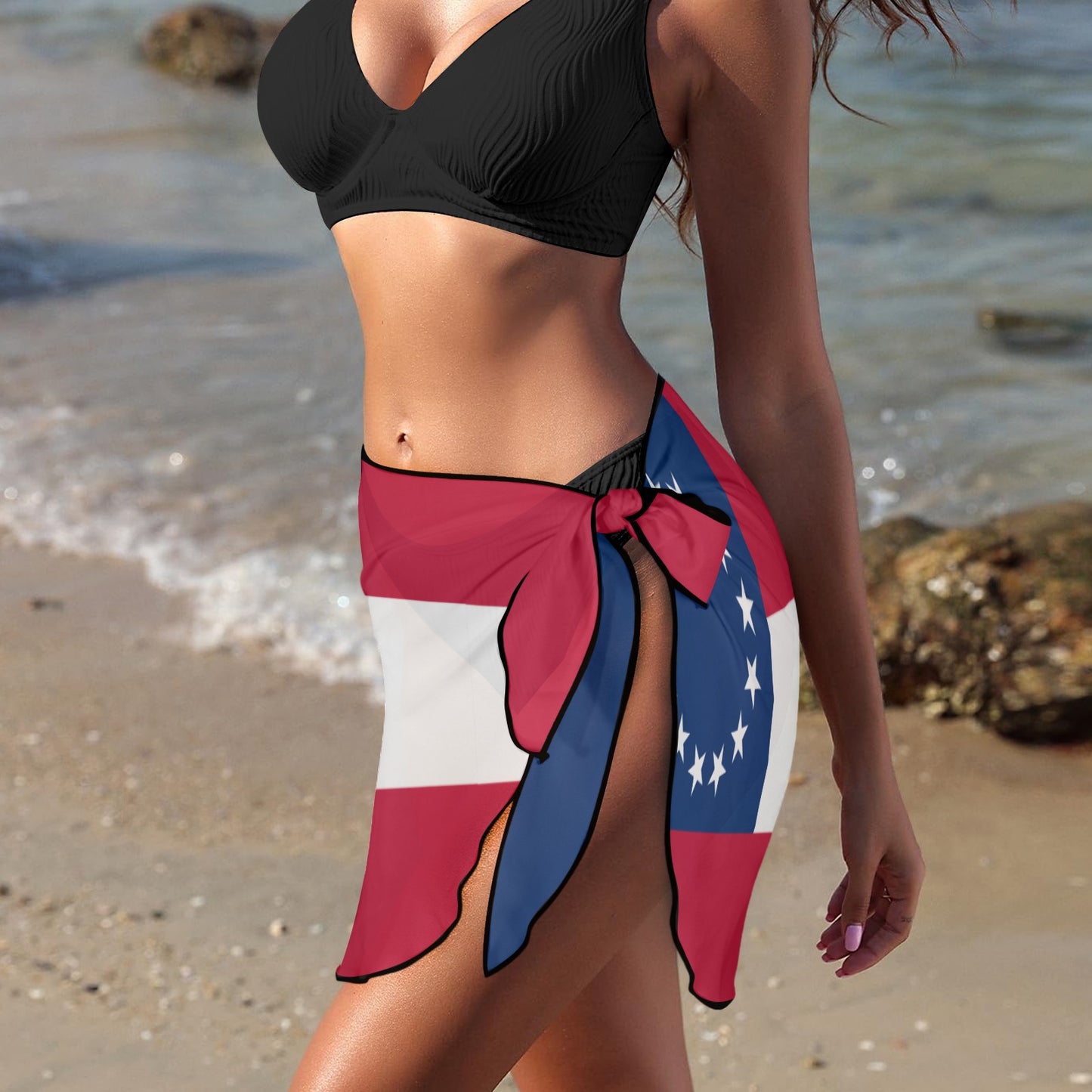 Woman wearing Luv My Flag sarong, beach in background.