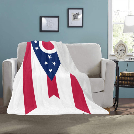 Luv My Flag blanket with starry, striped design on sofa.