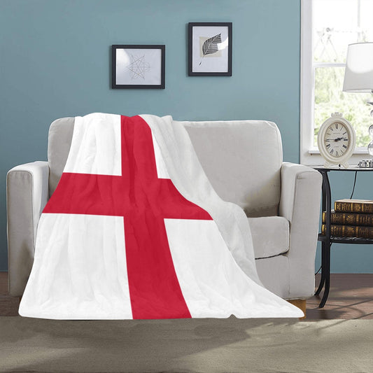 "Luv My Flag blanket with red cross, draped on sofa."
