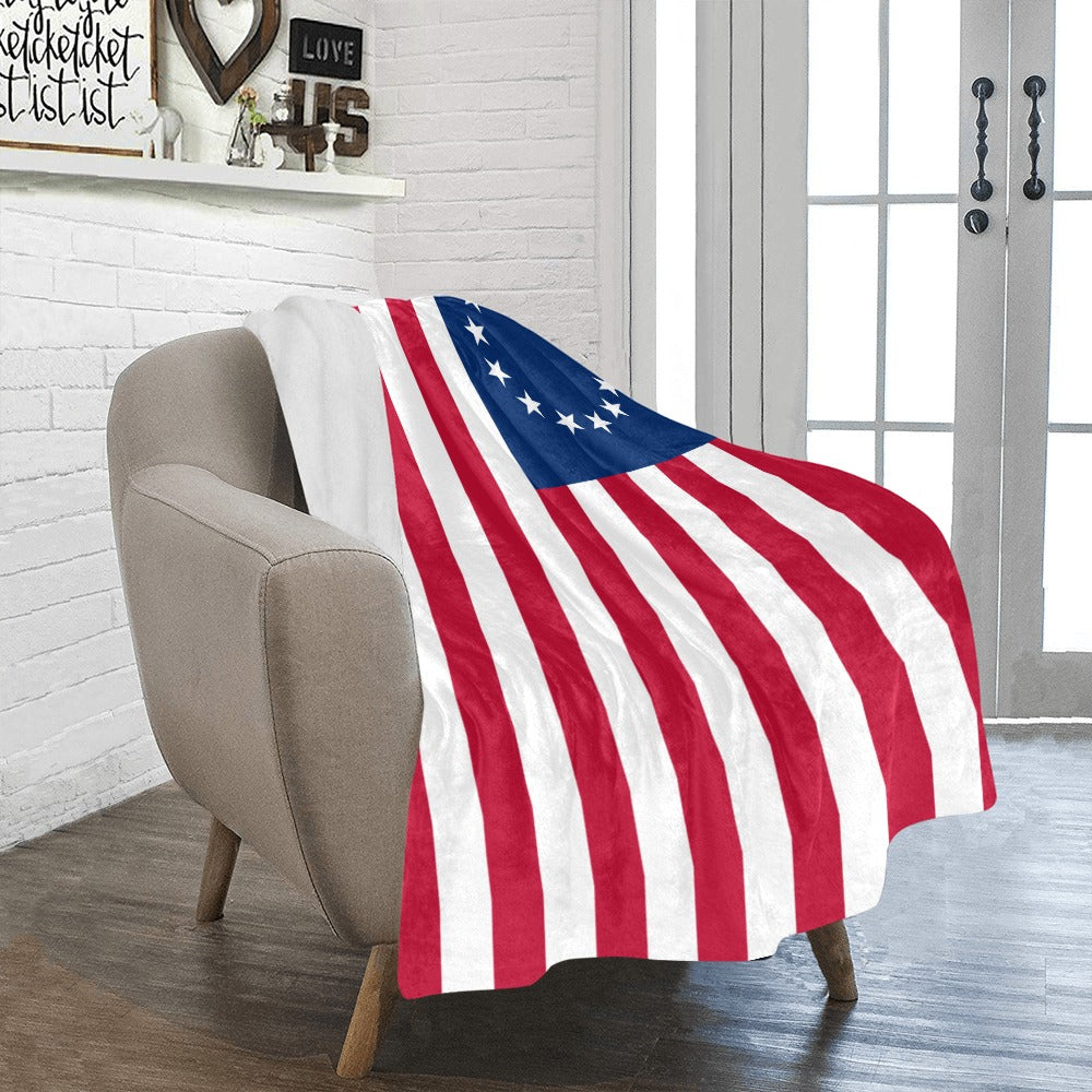 Luv My Flag blanket draped over a beige chair.