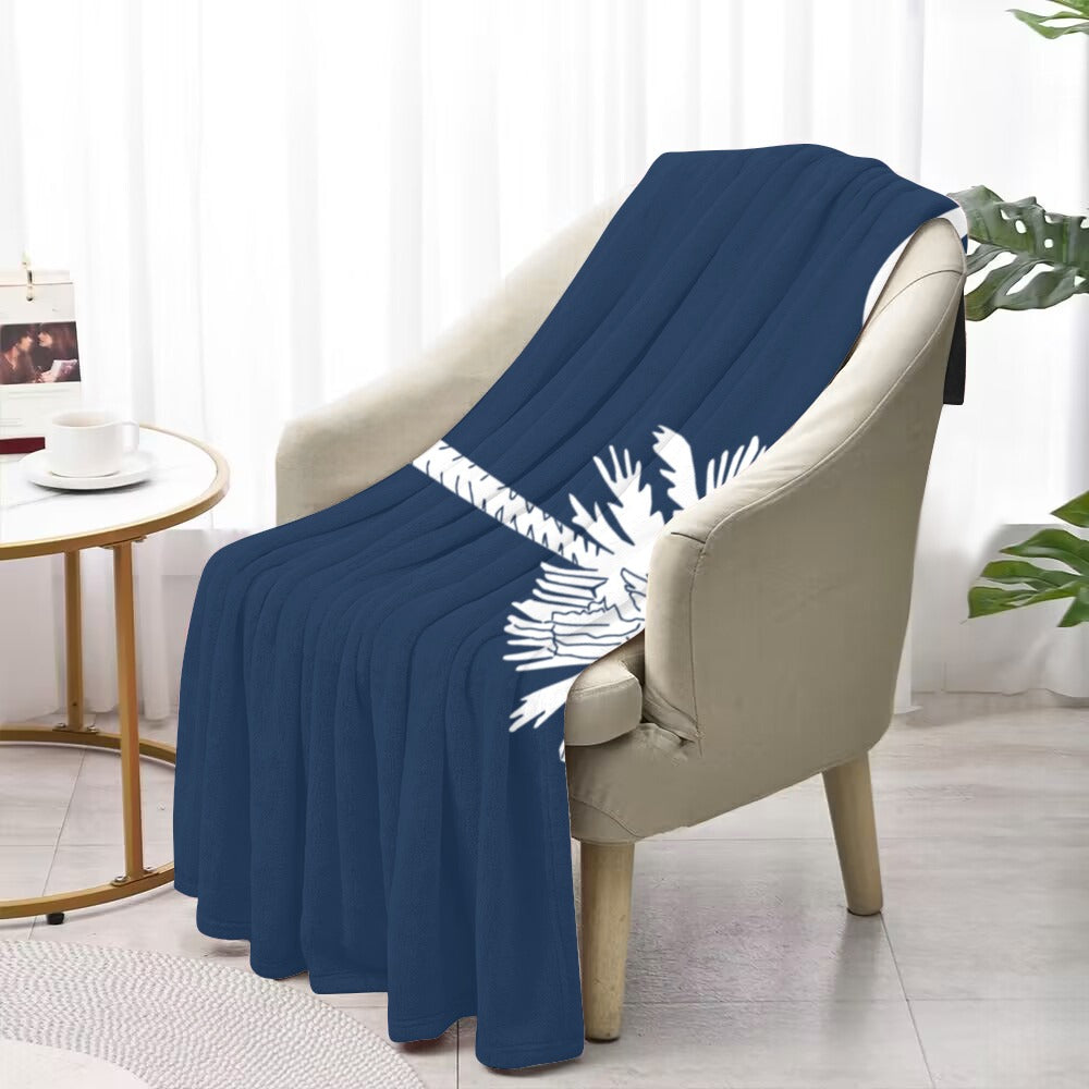 "Luv My Flag blue blanket draped over beige chair."