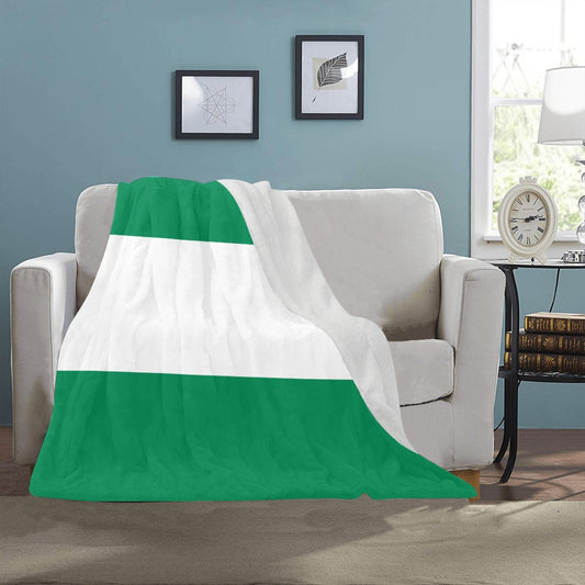 Couch draped with green and white Luv My Flag blanket.