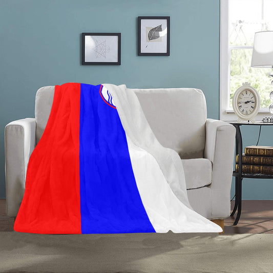 Luv My Flag blanket draped over beige couch, colorful design.