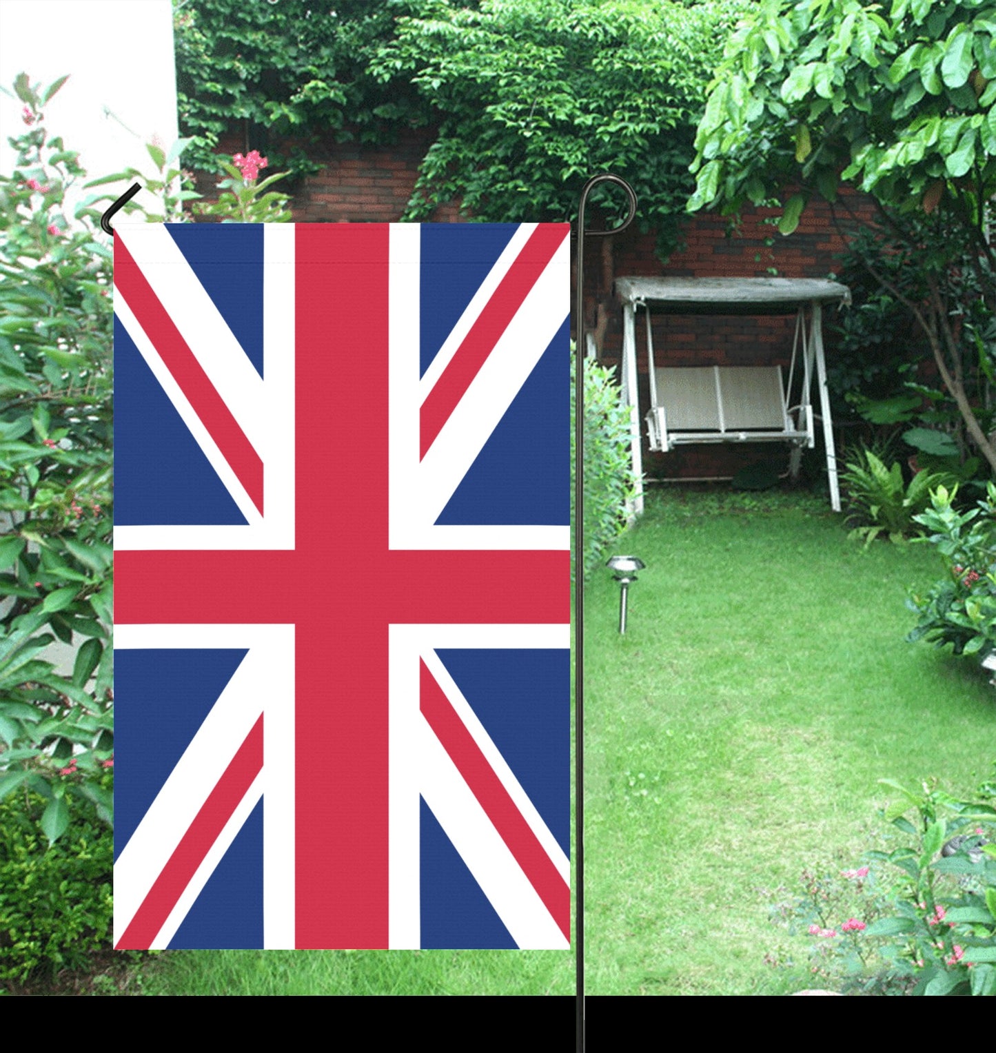 Luv My Flag Union Jack garden flag in lush garden.