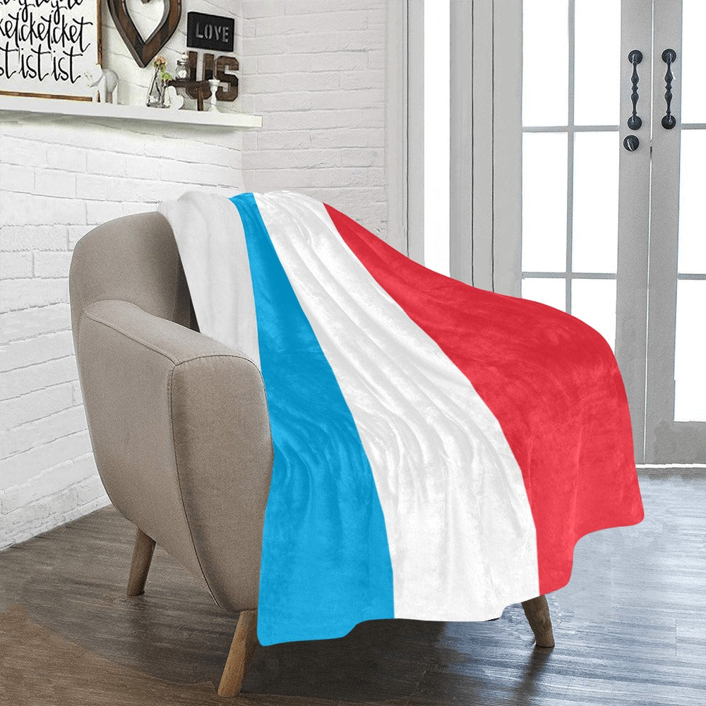 Cozy chair draped with Luv My Flag colorful blanket.