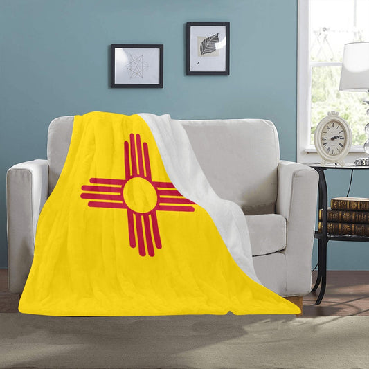 Luv My Flag blanket with Zia symbol on couch.