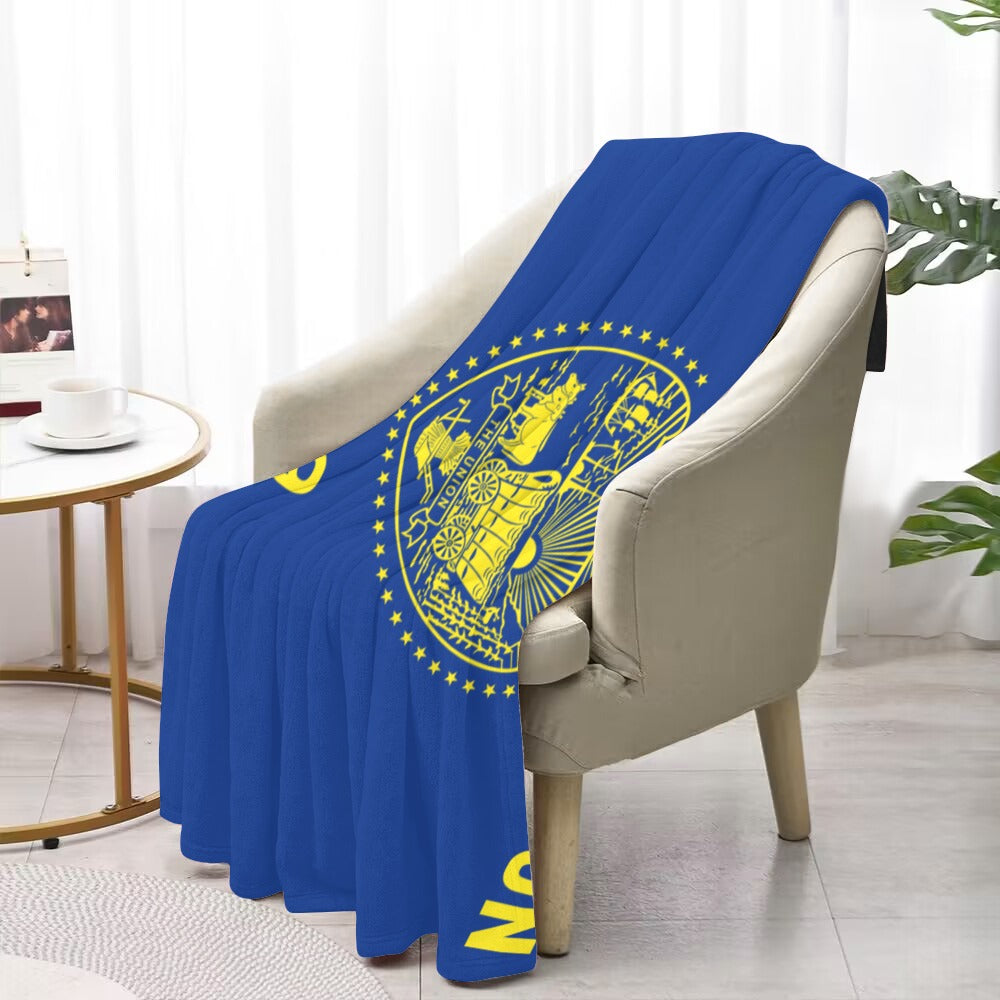 Soft blue blanket with yellow seal on chair, Luv My Flag.