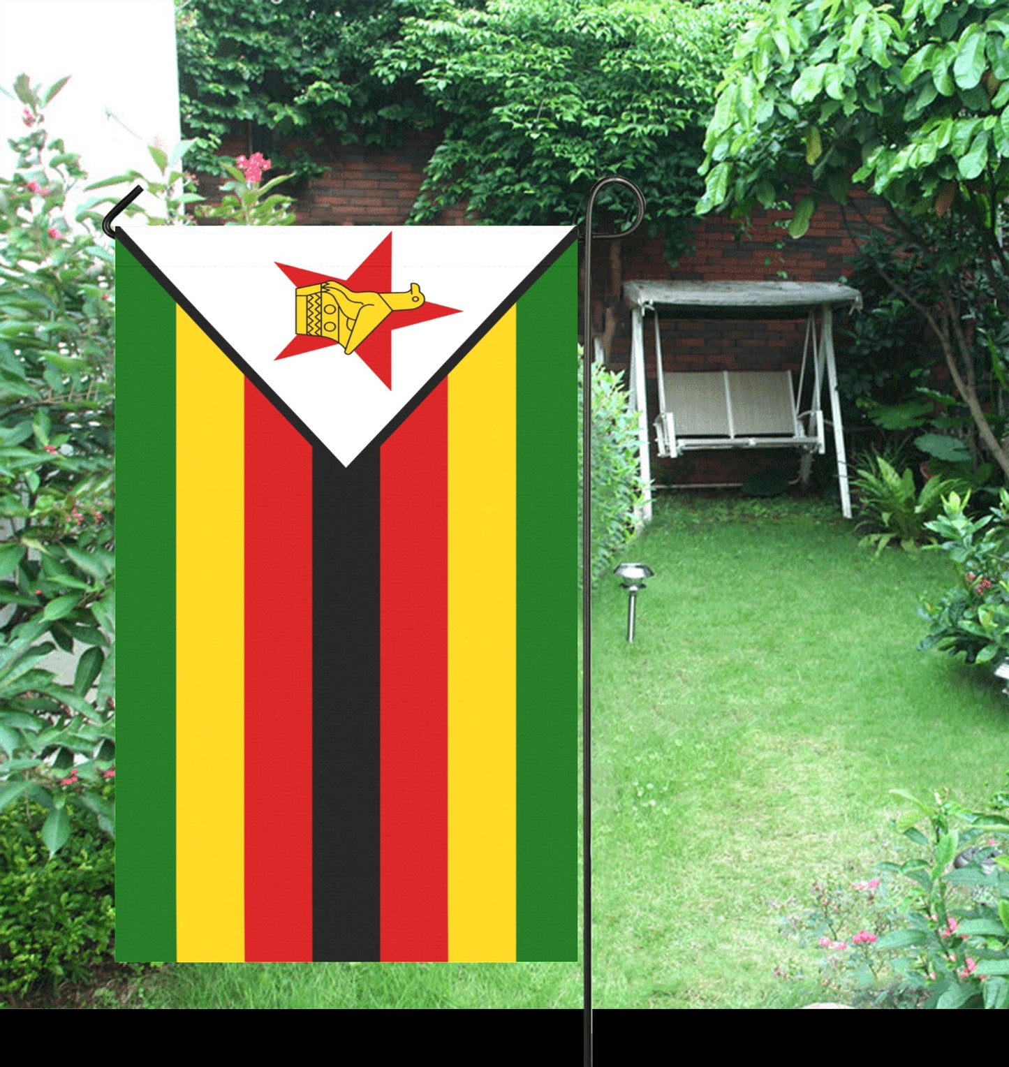 Luv My Flag Zimbabwe garden flag displayed amid lush greenery.