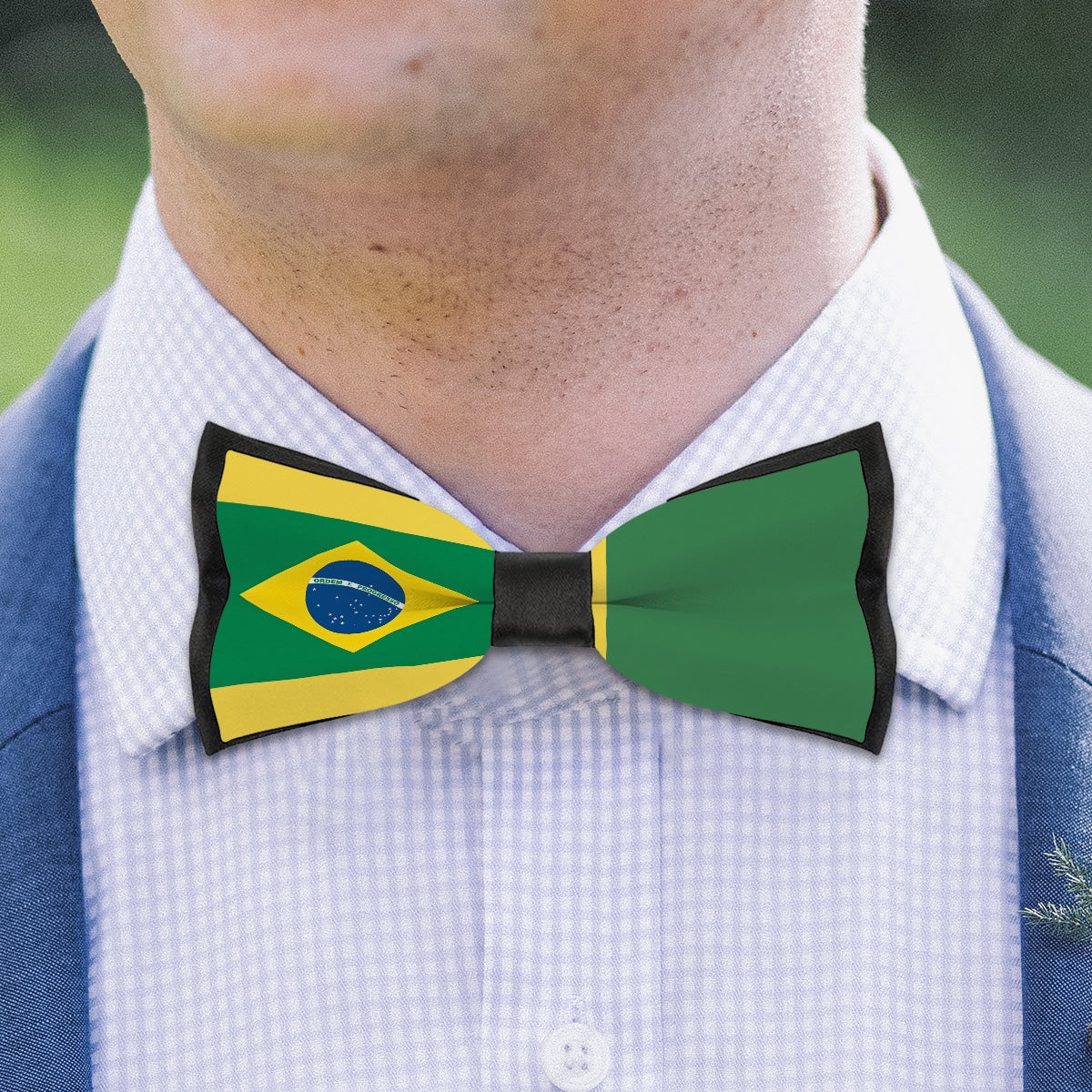 Man wears [Brand] bow tie featuring Brazilian flag design.