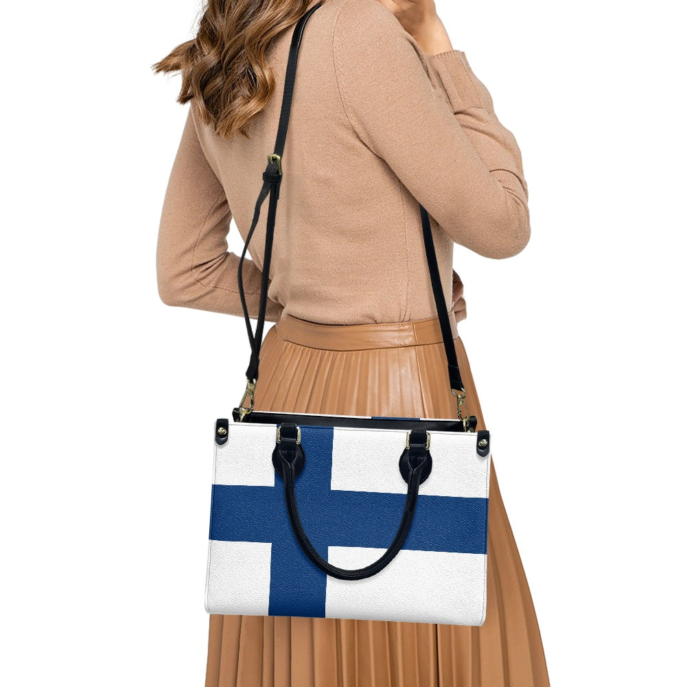 Woman wearing [Brand] handbag with Finnish flag design, stylish.