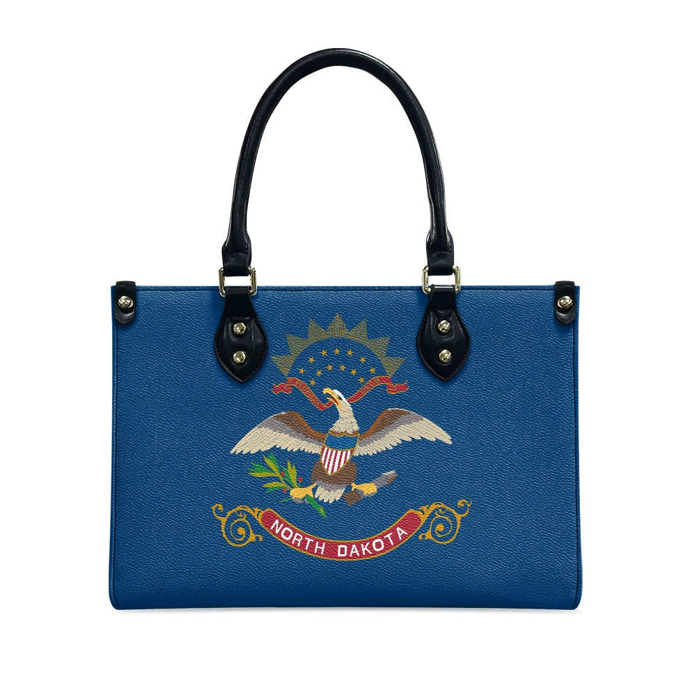 [Brand] handbag featuring North Dakota flag design on blue.
