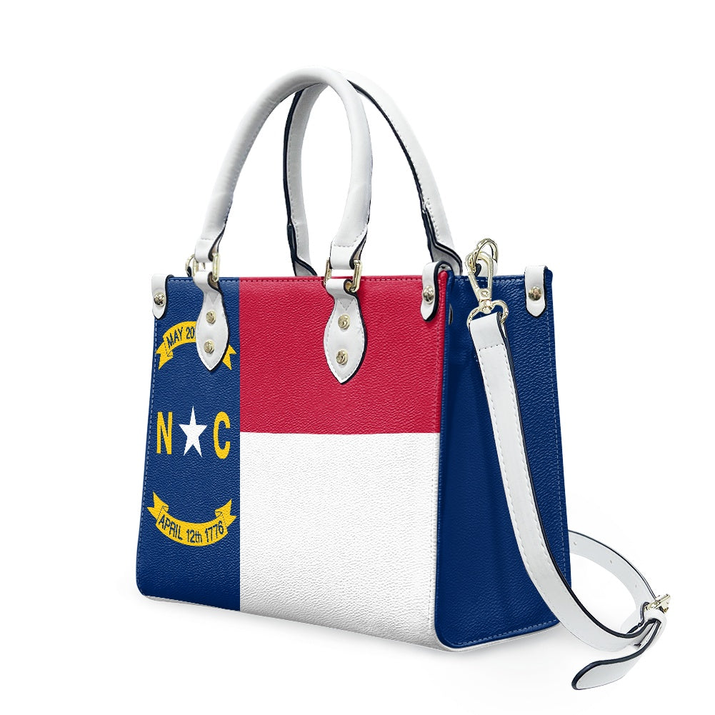 [Brand] handbag featuring North Carolina flag design, with strap.