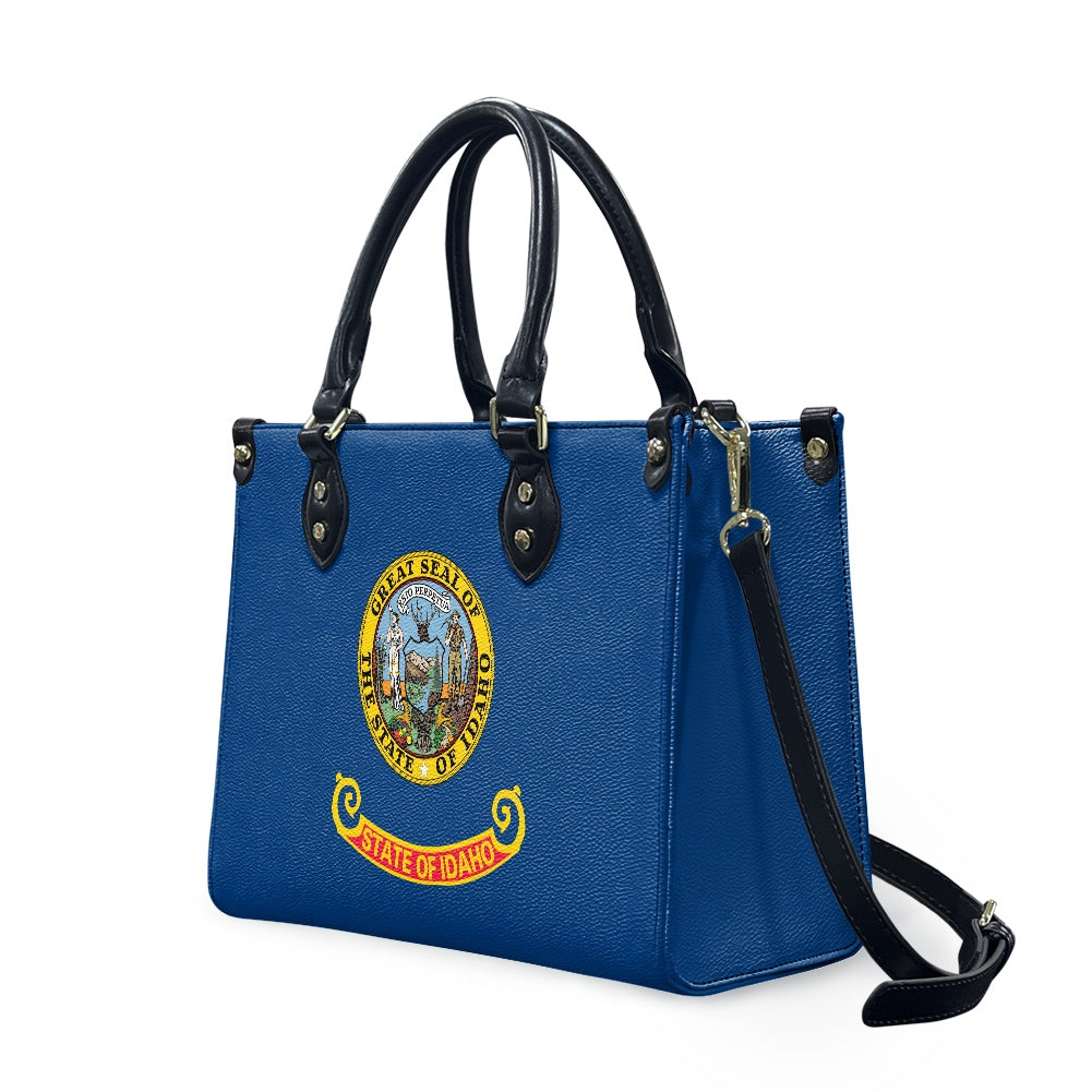Blue handbag featuring Idaho state seal, from [Brand].