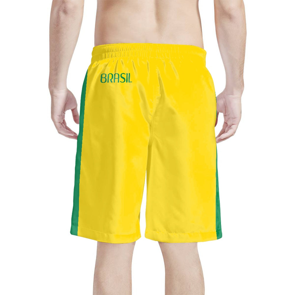 Back view of yellow and green Brazil flag beach shorts with the word BRASIL on the waistband, shown on model against a white background