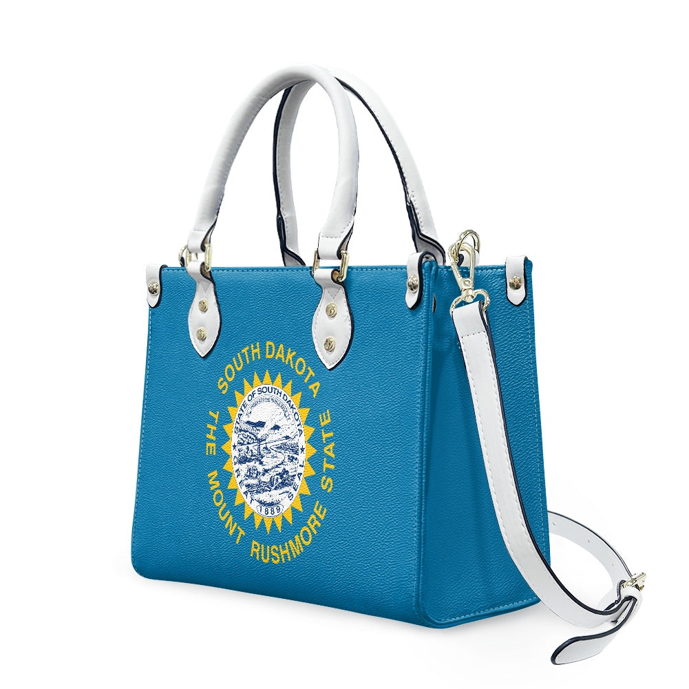 Blue handbag with South Dakota emblem, white handles. [Brand]