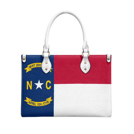 [Brand] handbag featuring North Carolina flag design, white handles.