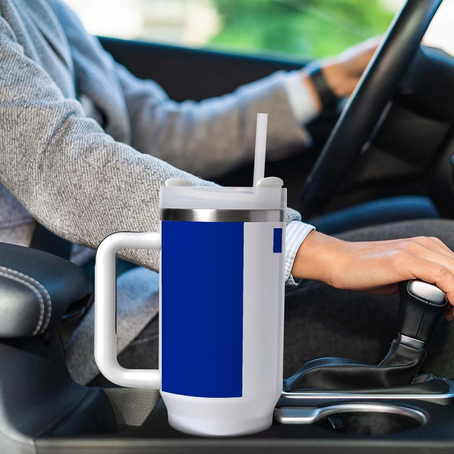 Person driving with a [Brand] mug in cup holder.