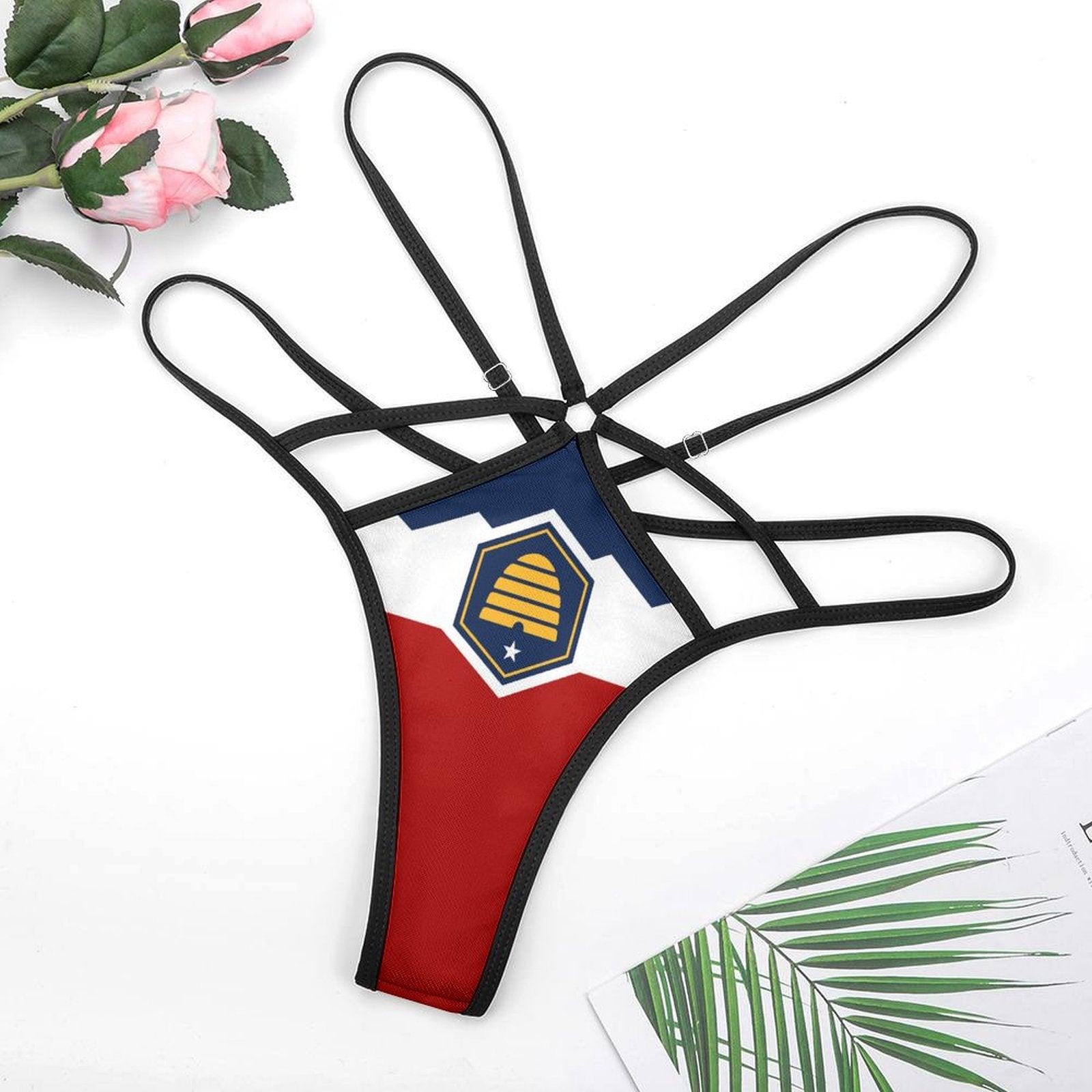 Black strappy thong with [Brand] logo on white background.