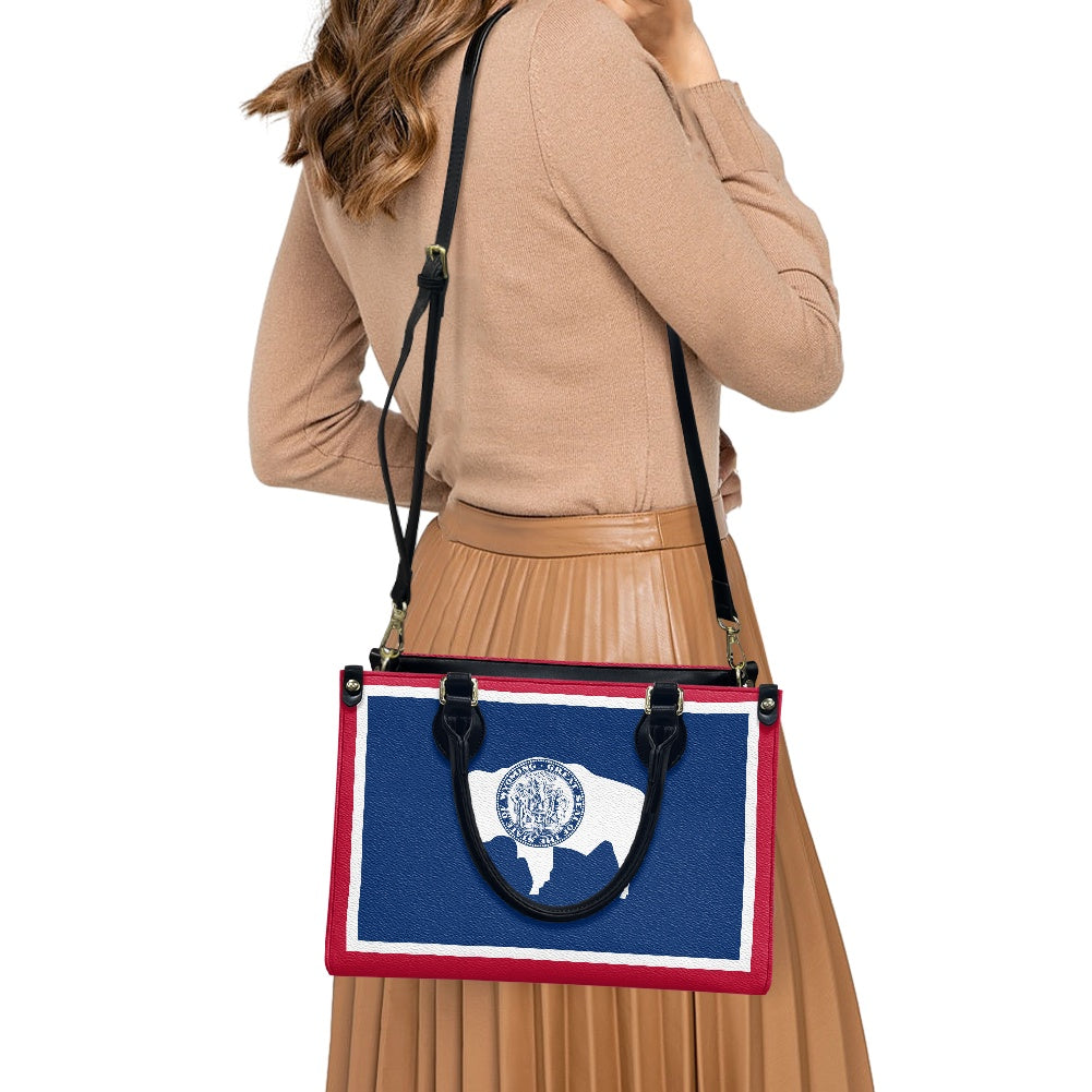 Woman carrying [Brand] handbag with Wyoming flag design.