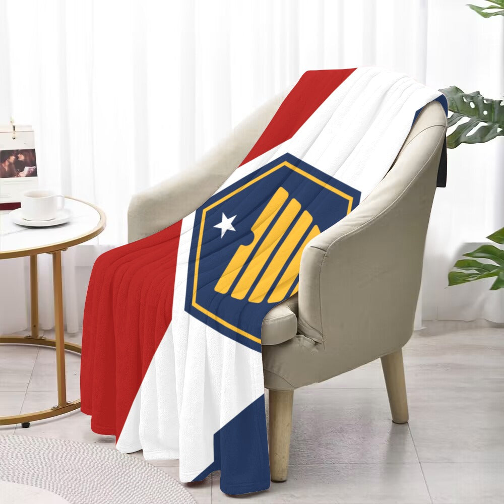[Luv My Flag] blanket draped over chair, featuring geometric design.