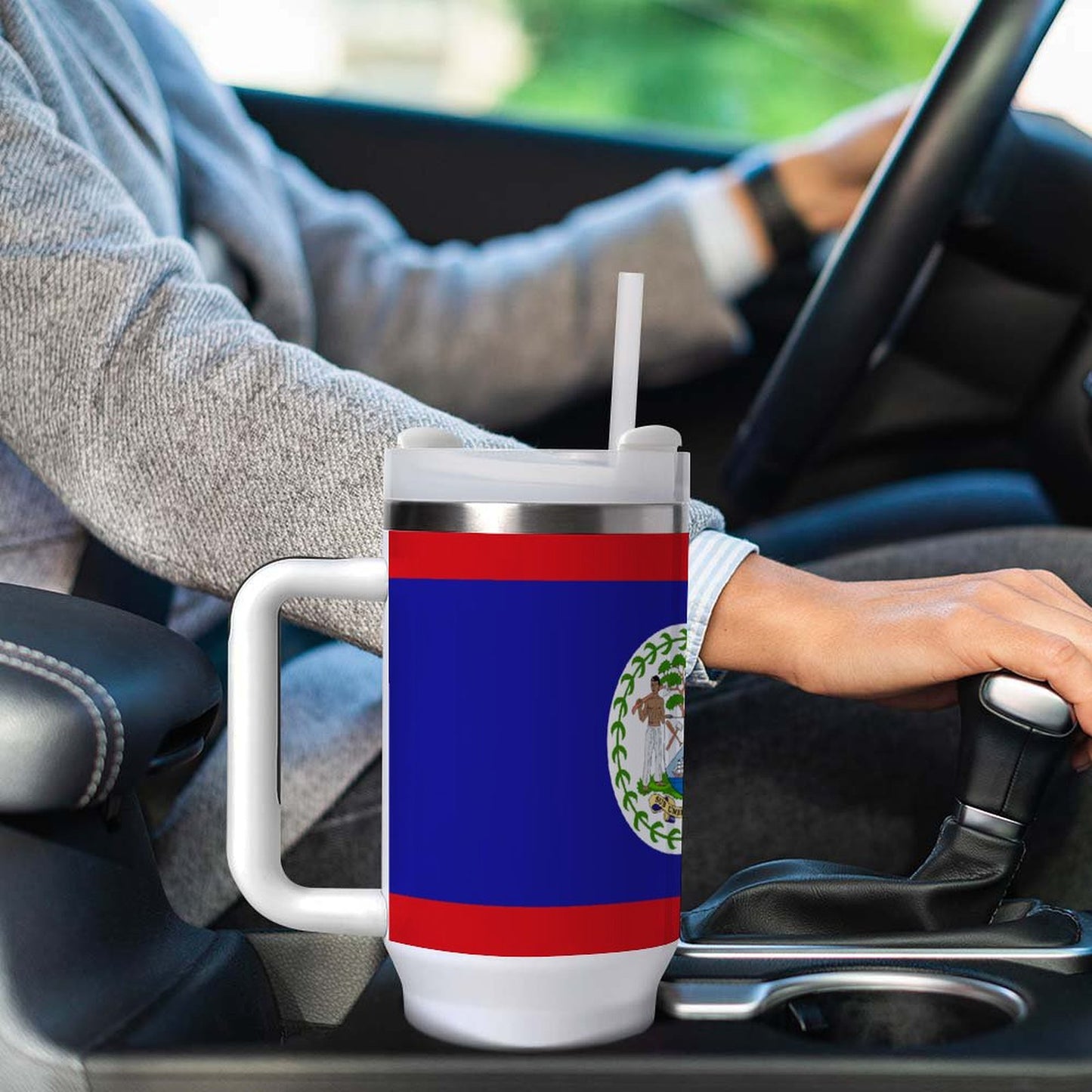 Person driving holding [Brand] mug with Belize flag design.
