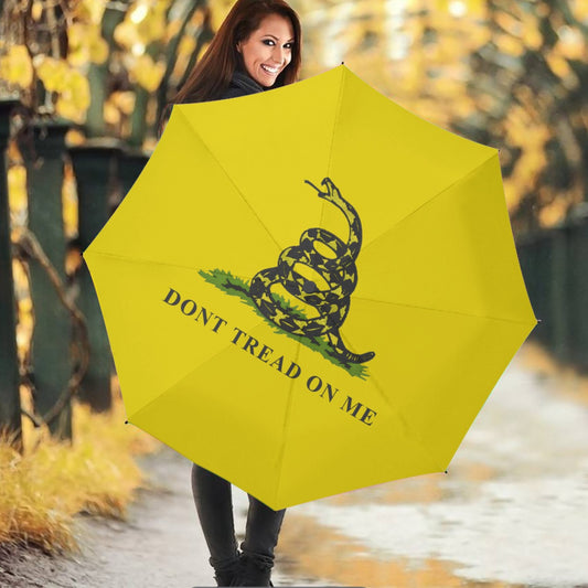 Woman holding yellow "[Brand]" umbrella with snake design.