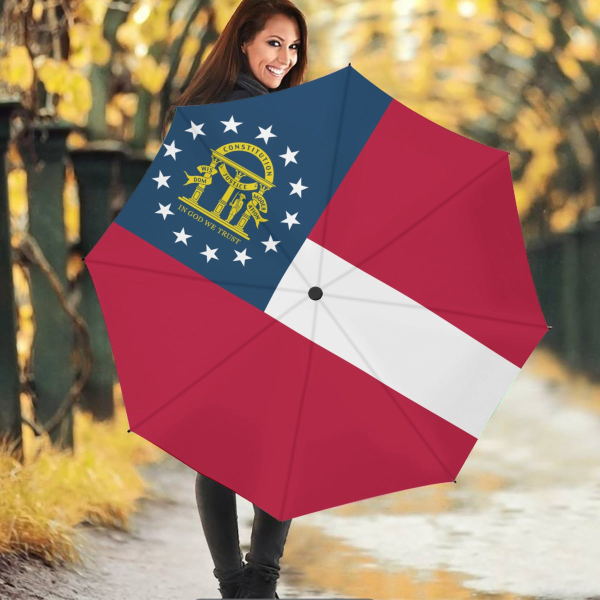 Woman with smile holding [Brand] umbrella featuring Georgia state flag.