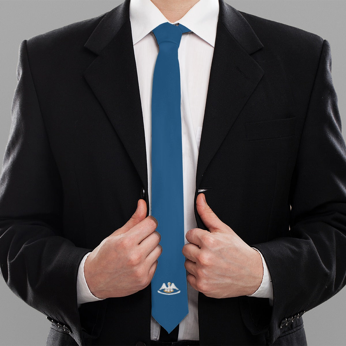 Man wearing black suit with blue [Brand] tie, adjusting.