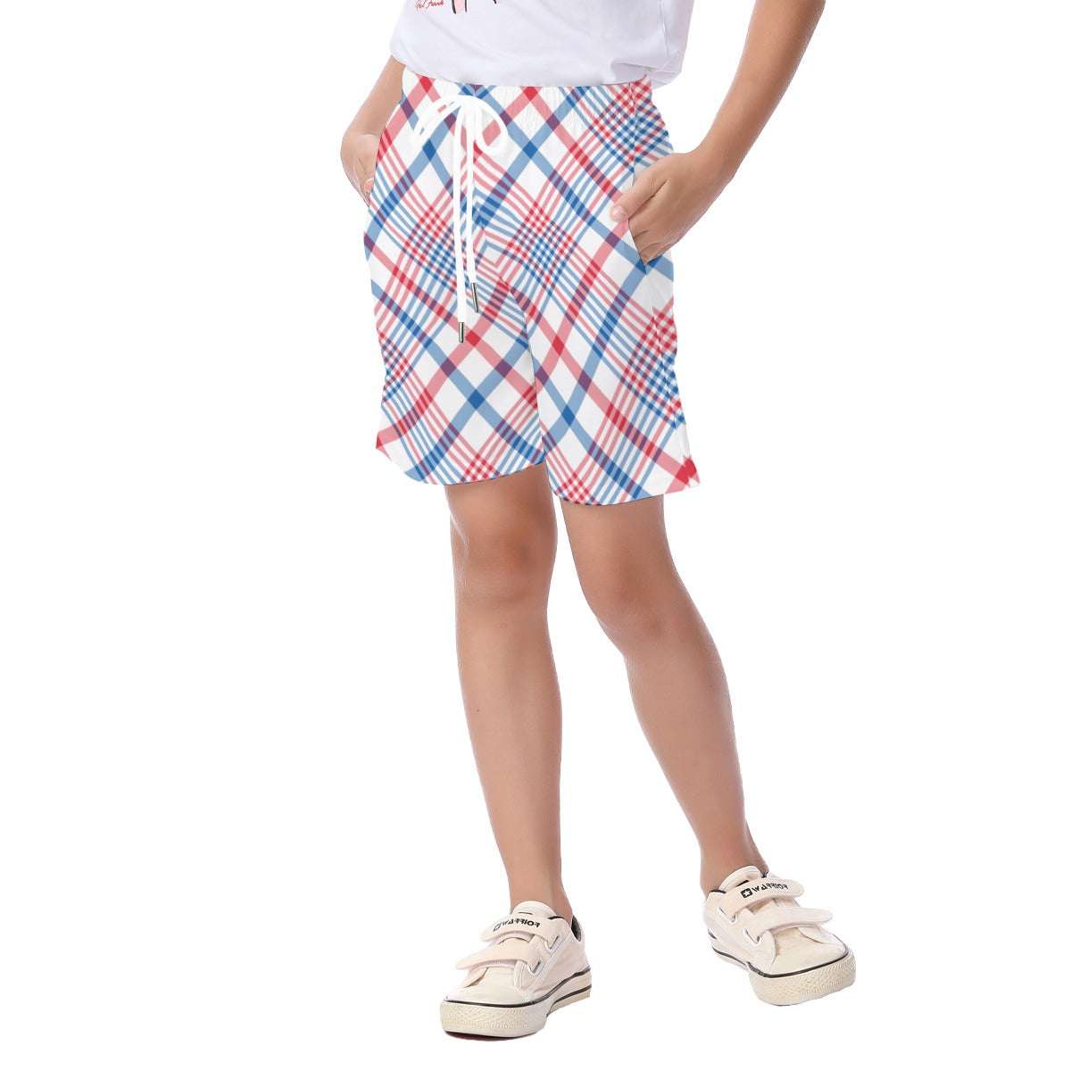 Child wearing [Brand] plaid shorts and white sneakers, hands pocketed.
