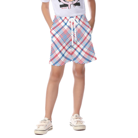 Young person wearing [Brand] plaid shorts and white sneakers.