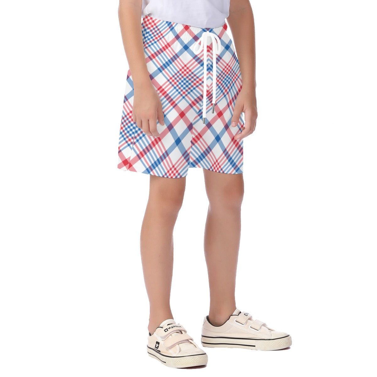 Child wearing [Brand] plaid shorts, white shoes, standing confidently.