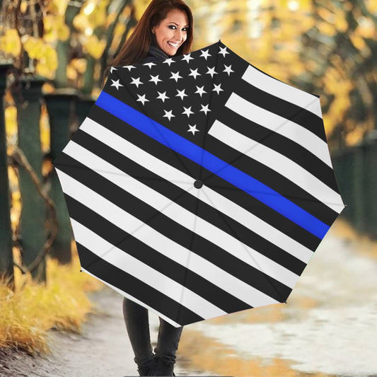 Woman holding [Brand] umbrella with blue line American flag.