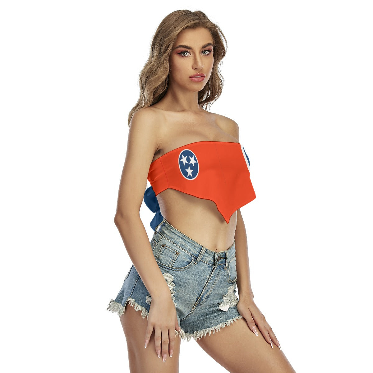 [Brand] model wearing orange top, denim shorts, white background.