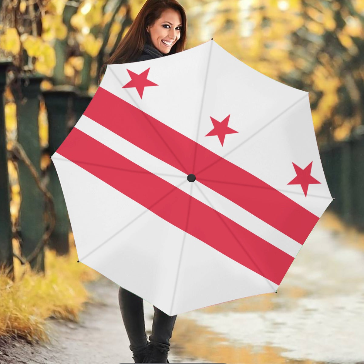Smiling woman holding [Brand] umbrella with stars design.