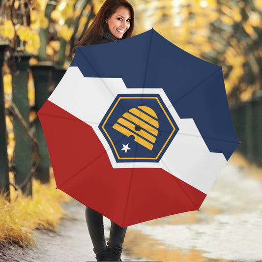 Woman holding stylish [Brand] umbrella with colorful design pattern.